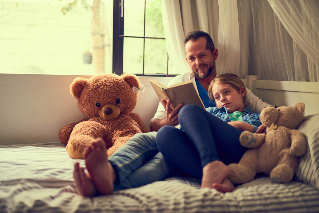 dad reading a book to daughter
